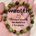 Hand holding tiger eye and green aventurine beaded bracelet for wealth and prosperity - Green Jade Tiger Eye-Wealth