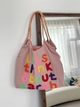 Detail of pink canvas tote featuring colorful 3D embroidery and checkerboard handles - Pink