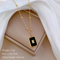 Detalle de collar dorado con colgante de esmalte negro y circón sobre joyero - Acero de titanio / T411 Dorado / Dorado