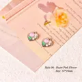 Macro shot of 14x16mm heart-shaped flower charms with pink petals and pearl accents - Style 06 Heart Pink Flower