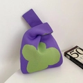 Detail of purple and green knitted knot bag showing the thick textured woven fabric - Purple Clover