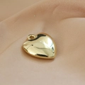 Detailed view of a polished golden heart-shaped resin pendant on soft beige silk fabric - 7# K-Gold Heart 7