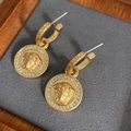 Dettaglio di orecchini vintage placcati oro con testa di Medusa e motivi greci - 39# Ago in Argento - Oro - Tondo
