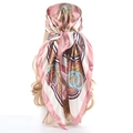 Pink satin square scarf with gold chain and blue ring pattern styled on head - Pink