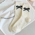 Wadenhohe Socken aus beigem Noppengarn mit schwarzen Schleifenmustern - Schleife