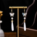 Golden butterfly earrings with white beads and teardrop pendants on a jewelry stand - E4360-3/Butterfly Rhinestone