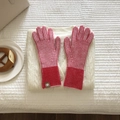 Detalle de guantes de punto de rayas rojas y rosas con puntas táctiles sobre tela - Rosa Rojo