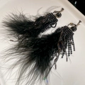 Vue détaillée de boucles d'oreilles en plumes noires avec strass brillants et longues chaînes - Clip-on - Noir