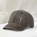 Macro shot of white faith cross embroidery on a washed dark gray vintage baseball cap - Coffee