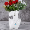 Artistic detail of blue heart necklace and gold earring on a white resin bust stand - White