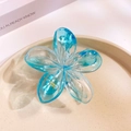 Blue translucent flower hair claw clip with golden spring on a ceramic plate - Transparent Blue