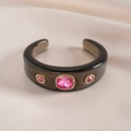 Macro-opname van hars manchetarmband met roze kristallen en gouden rand - Zwart - Framboosrood