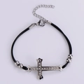 Dettaglio del bracciale a corda nera intrecciata con ciondolo a croce di strass e moschettone - Acciaio Cordino Nero Zirconia Rosso