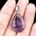 Natural purple amethyst teardrop pendant with silver bail held in hand over black background - Amethyst (1pc)