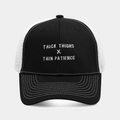 Detail der Trucker-Mütze mit der Stickerei 'THICK THIGHS X THIN PATIENCE' in Schwarz-Weiß - Schwarz+Weiß