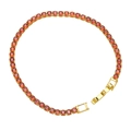 Macro view of gold tennis bracelet with round orange cubic zirconia and folding clasp - Orange