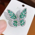 Macro shot of silver butterfly ring with emerald green stones and white crystal accents - Silver Green Zircon