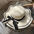 Creamy wide-brim straw hat with wavy edges and a large black ribbon bow for women - One Size / White
