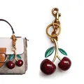 Sparkly red cherry bag charm with green leaves and gold-plated hardware on a purse - Red Large and Small Cherry with Green Leaf (Gold Plated)