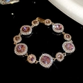 Detailaufnahme eines luxuriösen Goldarmbands mit rosa Kristallen und klaren Edelsteinen - Armband-Gold-Lila