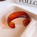 Close-up of vintage amber resin open bangle on a beige tray with artistic soft lighting - 28# Orange-Red Gradient Amber (28# Bracelet - Amber Color)