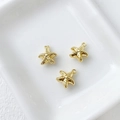 Detailed view of three 14k gold-plated starfish charms on a white ceramic plate - 2# Starfish