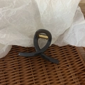 Detail of a glossy black hair claw clip featuring a metallic gold spring mechanism - Bright Light Coffee