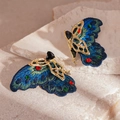 Vista detallada macro de pendientes de mariposa bordados con cristales sobre piedra - Estilo de Mariposa Azul (Con Pin de Plata de Ley 925)