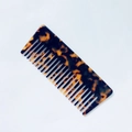 Dettaglio di un pettine a denti larghi in acetato tartarugato su sfondo bianco pulito - Stampa leopardata