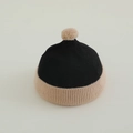 Detail of baby knit beanie with pompom showing ribbed texture and rolled brim - 50-52cm (2-4 Years) / Black & Beige