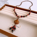 Dettaglio della collana boho in ceramica e conchiglia con corda intrecciata a mano - Collana-Marrone-Multicolore