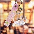 Pink flowing sand moon rabbit keychain with silicone wristband and golden bell charm - Pearl White