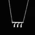 Macro shot of silver stainless steel 777 angel number pendant on a black background - 777 Steel