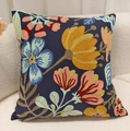 Square dark blue throw pillow cover with colorful floral embroidery on a soft beige sofa - Blue Pumpkin Flower (With Core)