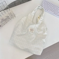 Detail of the woven fabric texture and colorful logo label on the plaid tote bag - Soft Purple Plaid