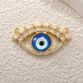 Macro detail of gold evil eye charm with blue center and white zircon crystals for DIY jewelry - A0257