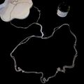 Dettaglio macro della catena corpo argento con nappine di strass e cristalli lucidi - Argento