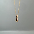 Detail of a polished gold teardrop pendant on a fine link chain with metallic luster - Letter I Single Pendant