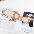 Detail of beige woven straw belt featuring a round wooden buckle on a fashion magazine - Round Buckle White