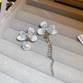 Macro detail of asymmetric silver floral earrings with crystals and pearl tassels - Asymmetric Flower Tassel Pearl