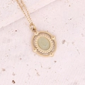 Close-up of a gold necklace featuring an oval green gemstone pendant with beaded edges - Vintage Beaded Edge Green Gemstone Oval Style (2#)