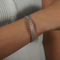 Eleganter silberner Armreif in Weizenähren-Form am Handgelenk eines Models - Silber