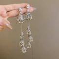 Detailed close-up of ethnic silver Jhumka earrings with intricate bell tassels design - Wind Chime Tassel Drop / Silver