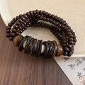 Dettaglio macro del bracciale vintage in guscio di cocco e perline di legno marrone scuro - Stile multistrato caffè scuro