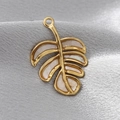 Macro detail of a golden monstera leaf pendant with natural white shell inlay on grey silk - White Leaf