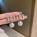 Dettaglio degli orecchini a lettera CD dorati con perle incastonate e pendente - Orecchini a Bottone con Perla Dorata Lettera D (HE10045)