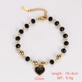 Detailed view of a gold-tone heart charm bracelet with black beads and size labels - Style 8 (Rhinestone Heart Charm)