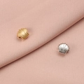 Set aus goldenen und silbernen Muschelanhängern aus Edelstahl auf rosa Stoff - Quadratische Muschel / Stahlfarbe