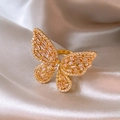 Eleganter goldener Schmetterlingsring mit Zirkonia auf champagnerfarbenem Seidenstoff - Gold