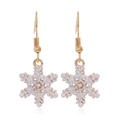 Macro detail of gold-tone snowflake earrings with sparkling pink and white glitter - Snowflake #15